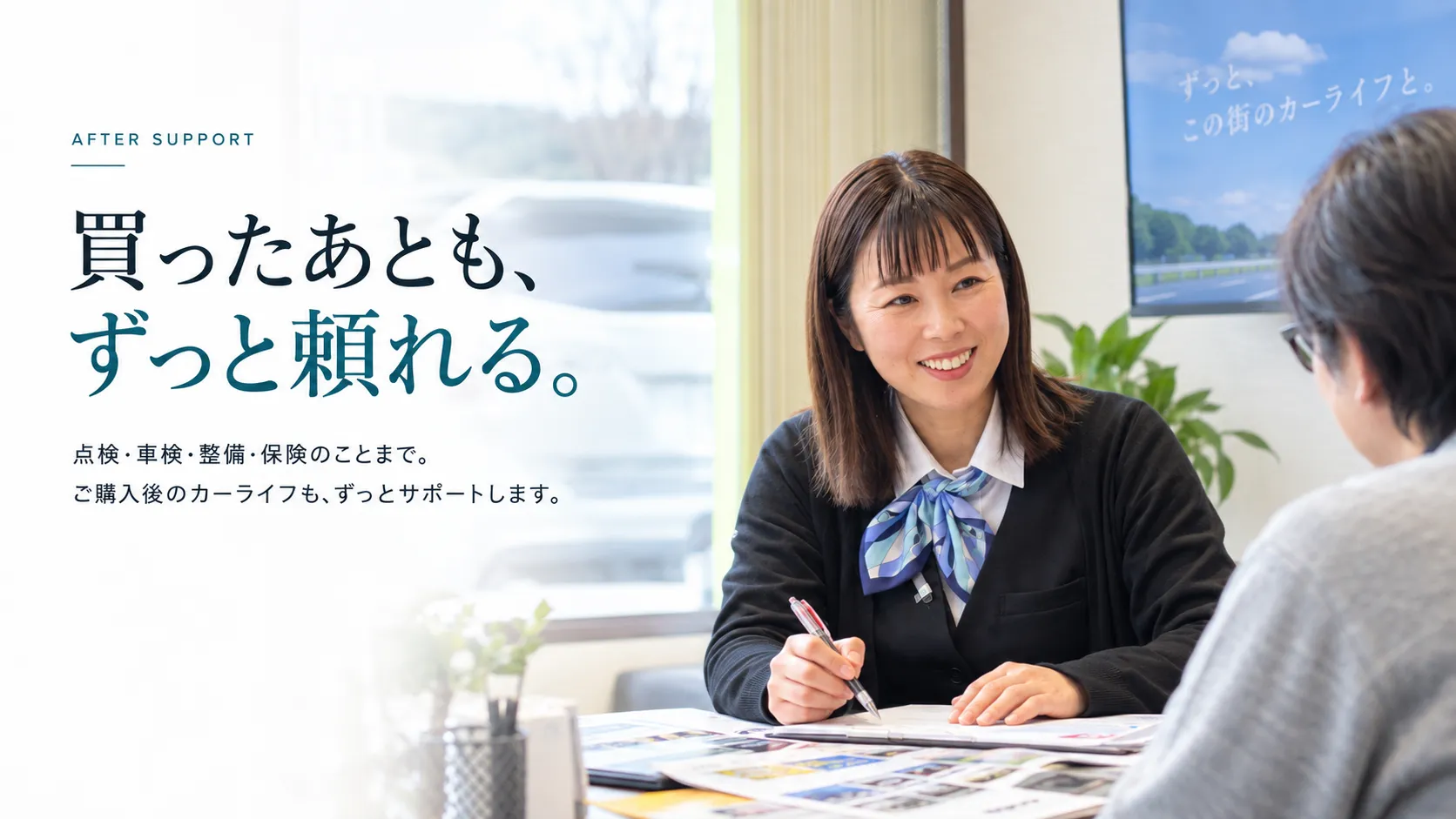 伊万里の出雲商会で女性スタッフがお客様の購入後のカーライフ相談に対応する様子