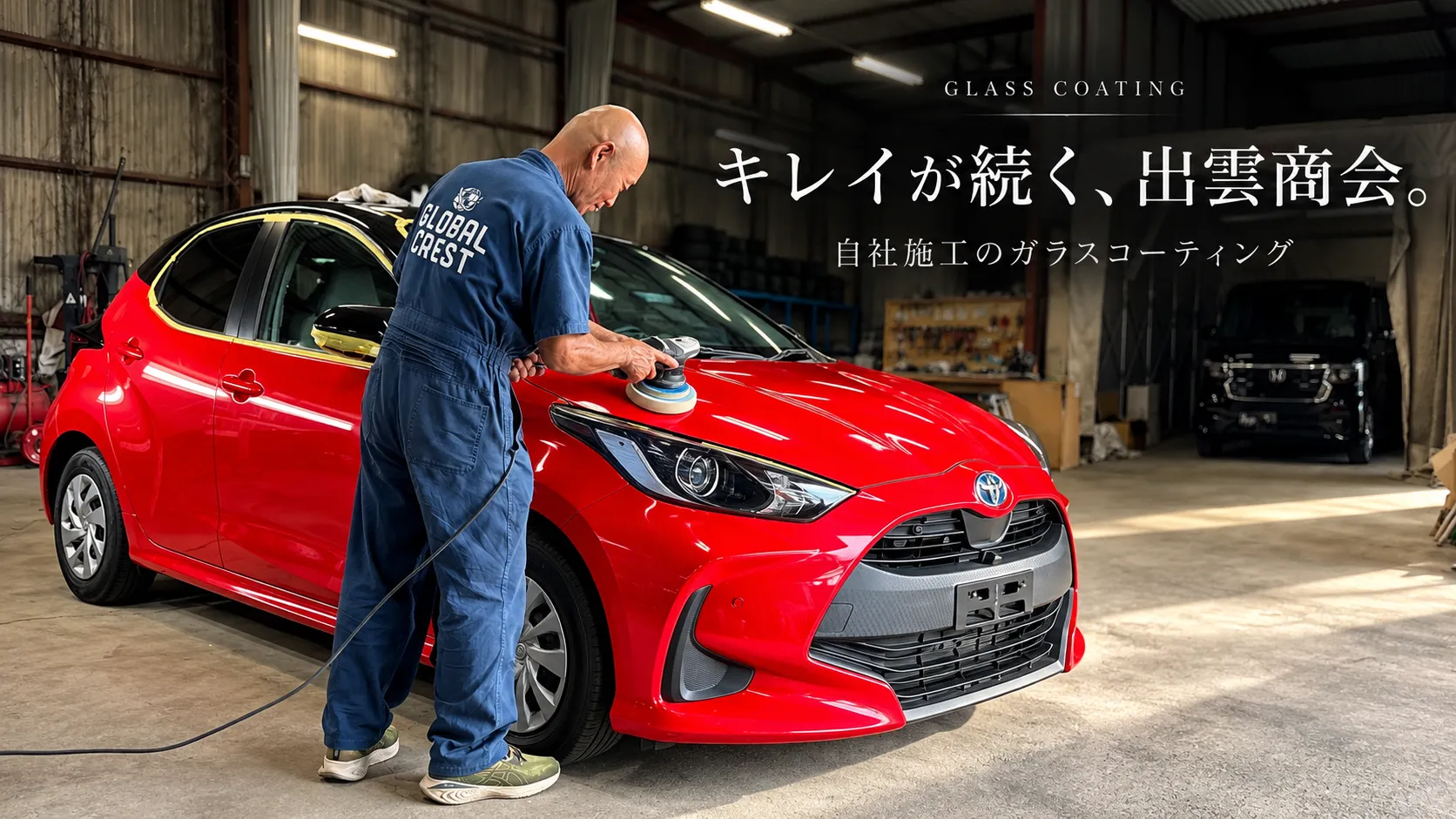 赤い車へガラスコーティングを施工する職人。伊万里の株式会社 出雲商会による自社施工のガラスコーティング